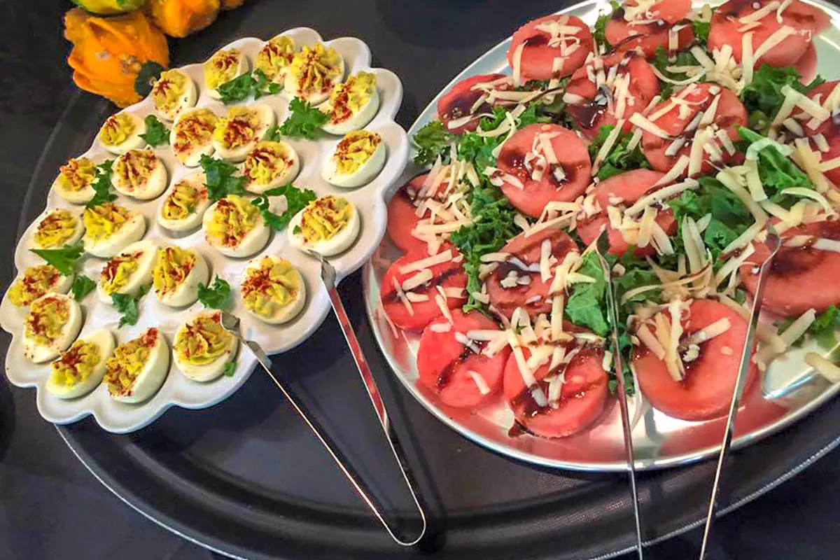 Deviled eggs and a tomato salad on a catering table