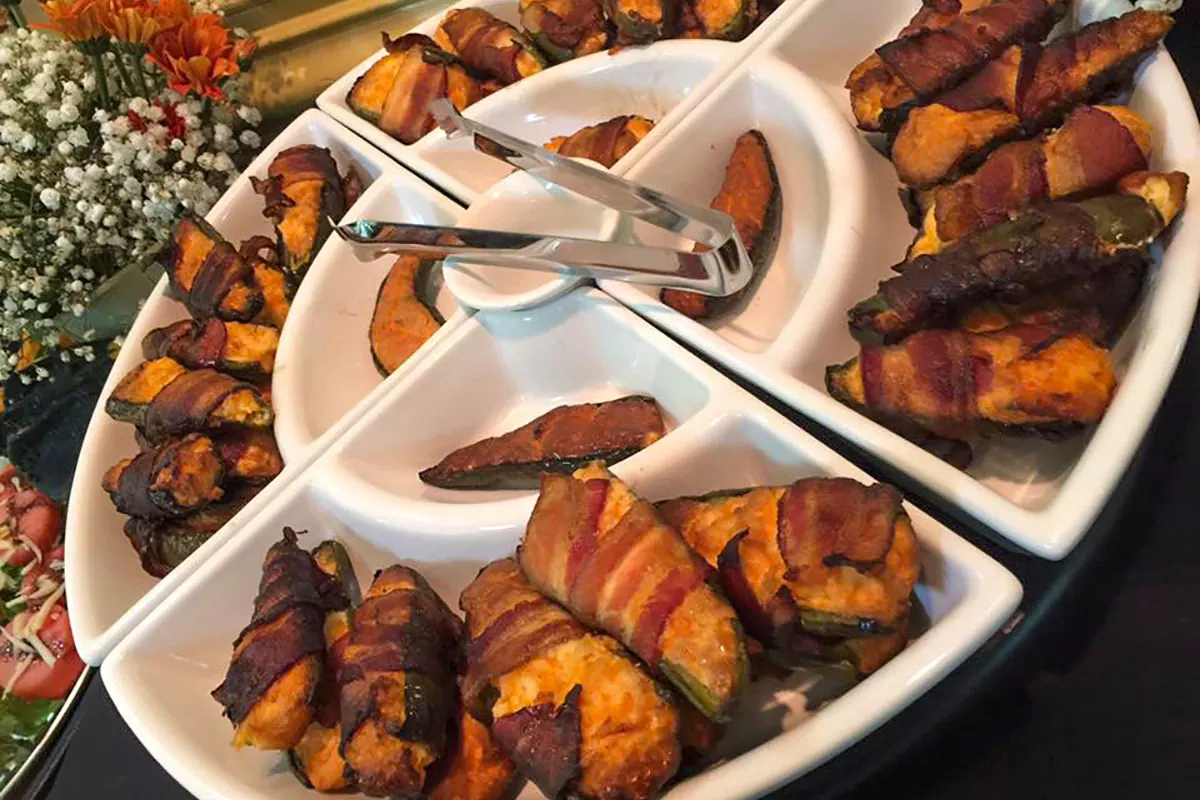 Catering trays of bacon-wrapped bites and sweet potatoes