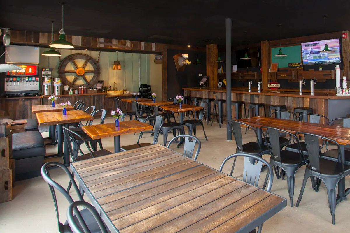 The dining room: wood tables, metal chairs and barn-wood walls