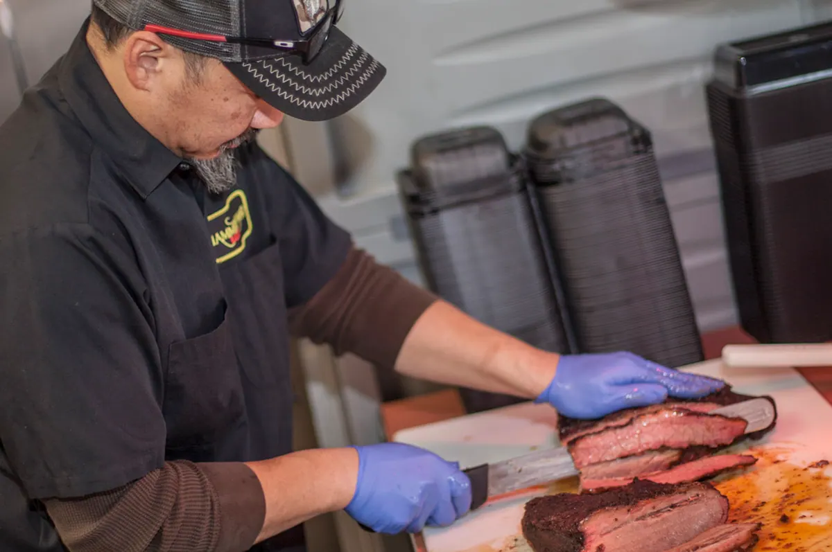 Ken slicing a brisket at the block
